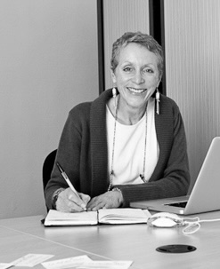 portrait de gislaine ariey à son bureau devant son ordinateur 
