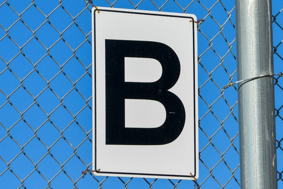un panneau blanc et noir sur un poteau métallique