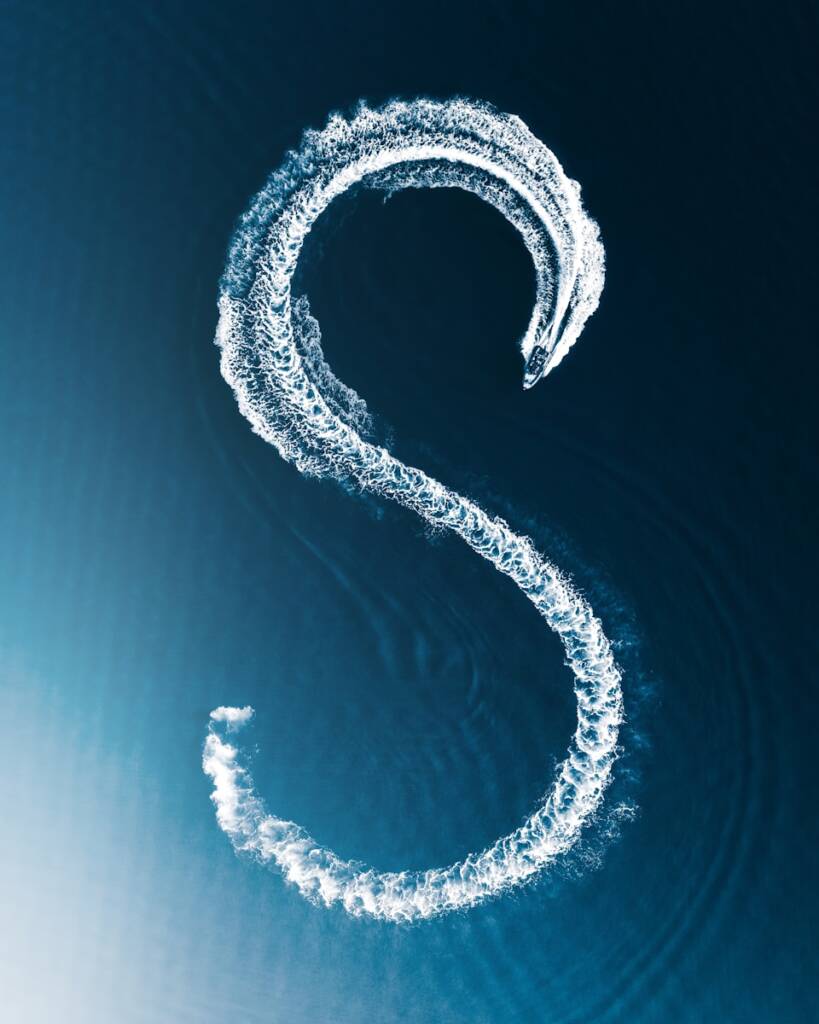 sillage blanc en forme de S sur mer bleu profond