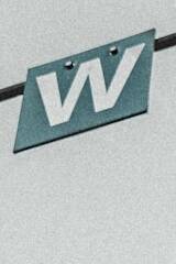 lettre W blanche sur panneau de signalisation gris