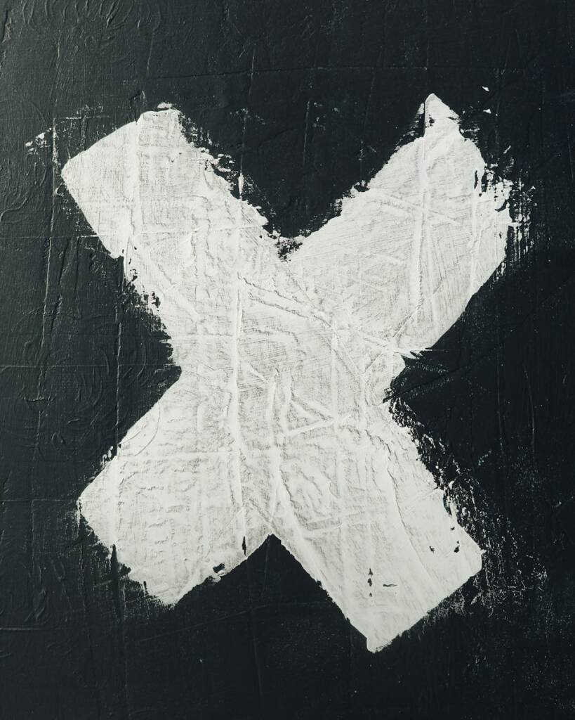 lettre x en blanc sur mur noir